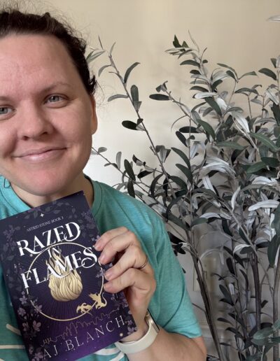 woman holding a book, Razed in Flames and smiling